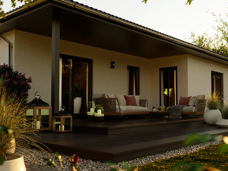 Winkelbungalow 108 – Detailansicht Terrasse mit Verschattung im Tageslicht Frontale Nahaufnahme der Terrasse des Winkelbungalow 108 mit bodentiefen Fenstern, modernen Sitzmöbeln und Blumenschmuck bei Tageslicht.