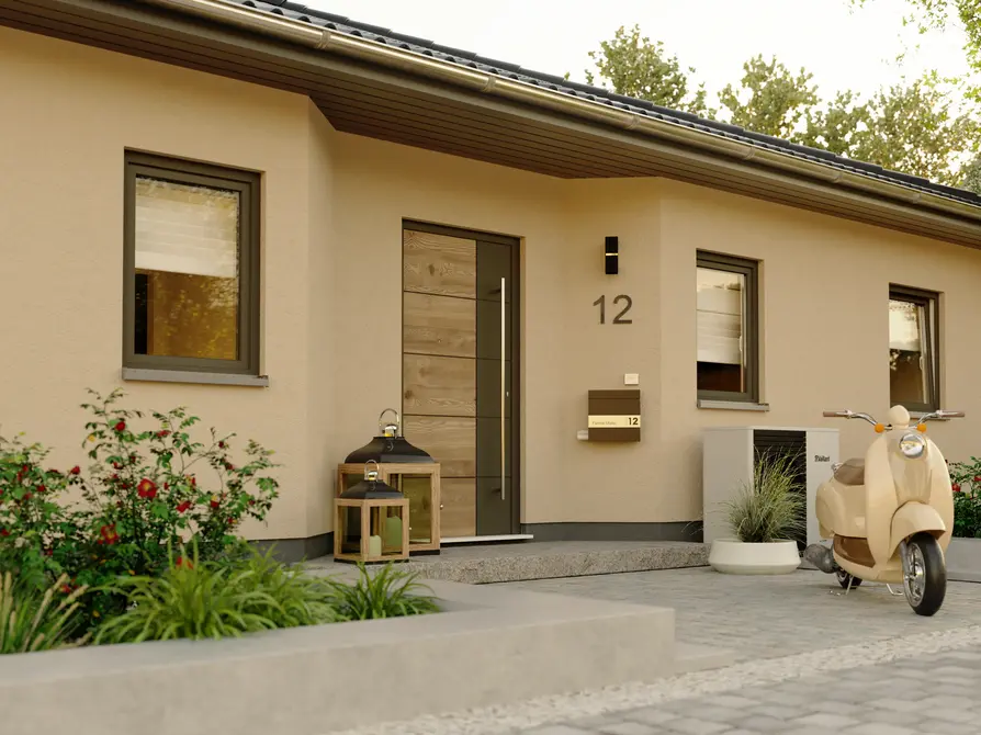 Detailansicht des Eingangsbereichs vom Winkelbungalow 108 mit moderner Haustür in Holzoptik, eleganter Beleuchtung und dekorativen Laternen.